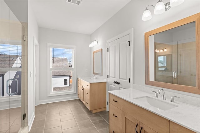 bathroom with tile patterned flooring, vanity, and a shower with shower door