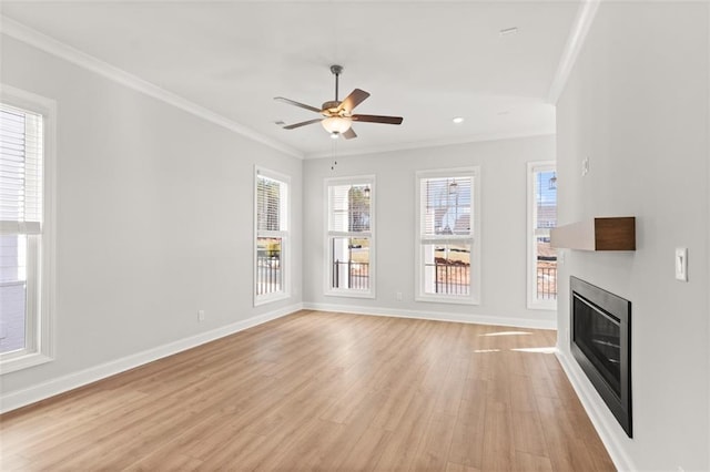 unfurnished living room featuring crown molding, a wealth of natural light, ceiling fan, and light wood-type flooring