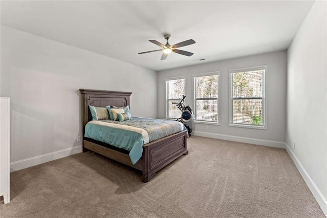 bedroom featuring light colored carpet, a ceiling fan, and baseboards