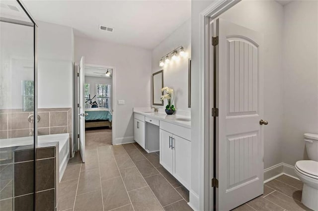 bathroom featuring visible vents, toilet, connected bathroom, double vanity, and baseboards