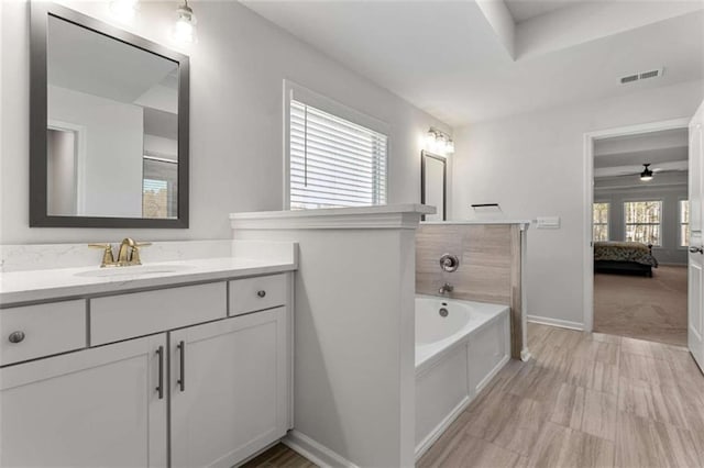 ensuite bathroom with visible vents, vanity, a garden tub, and ensuite bathroom