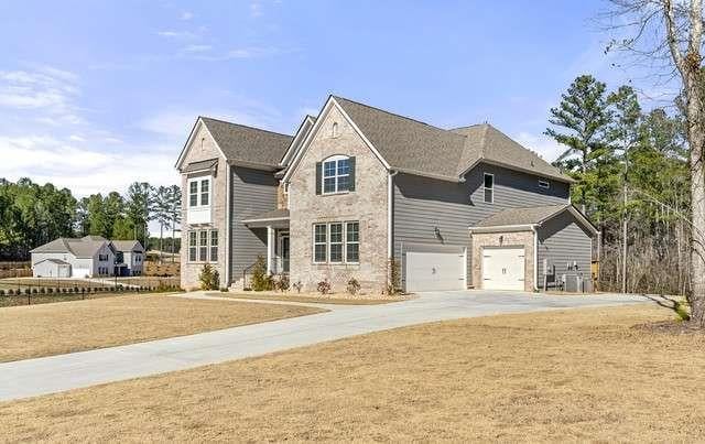 traditional home featuring a garage, concrete driveway, and a front yard