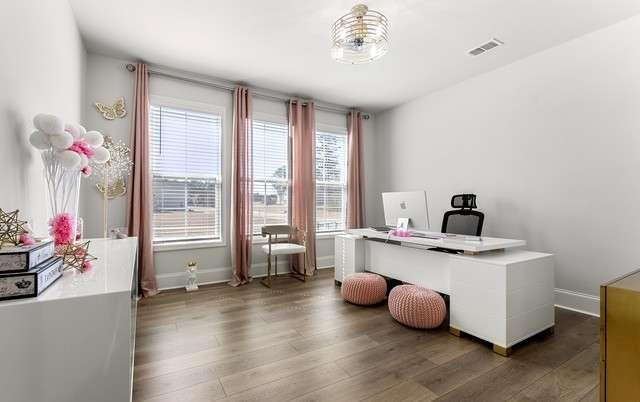 office area featuring wood finished floors, visible vents, and baseboards