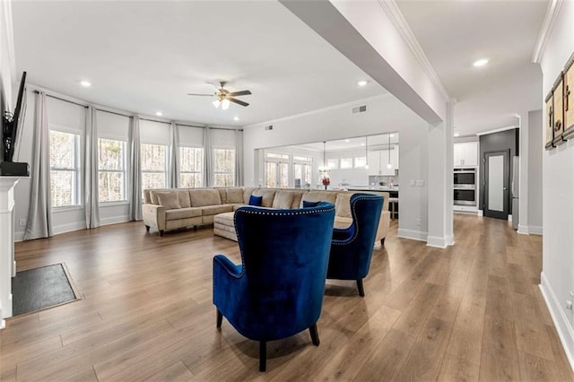 living room with visible vents, ornamental molding, a ceiling fan, recessed lighting, and light wood finished floors