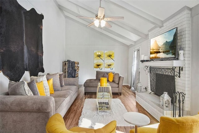 living room with hardwood / wood-style flooring, ceiling fan, a fireplace, and lofted ceiling with beams