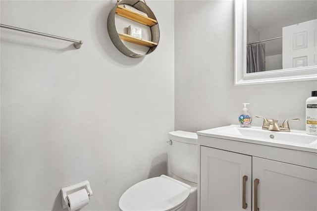 bathroom with toilet, vanity, and a shower with curtain