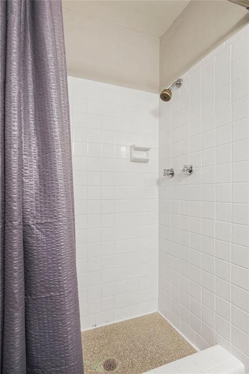 bathroom with tile walls and a shower with shower curtain