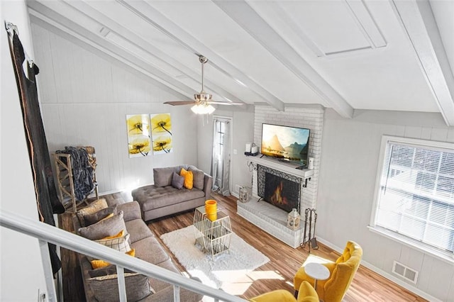 living room featuring a fireplace, hardwood / wood-style floors, ceiling fan, and a wealth of natural light