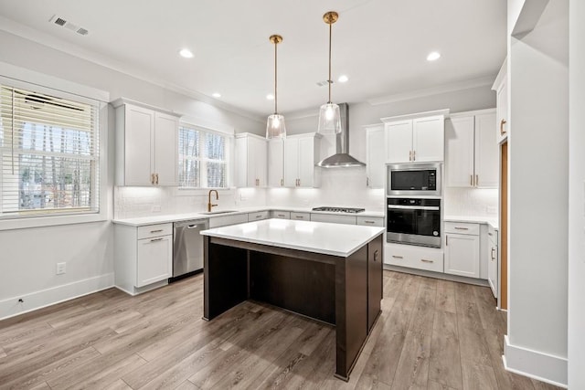 3390 Hillshire Dr, Cumming, GA 30028 - kitchen featuring appliances with stainless steel finishes, wall chimney exhaust hood, a sink, ornamental molding, and light countertops