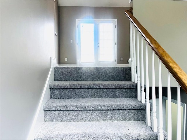 stairway with french doors and baseboards