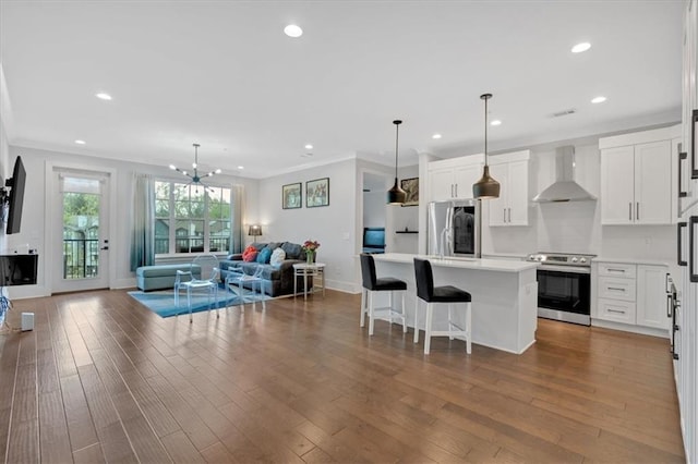 6890 Peachtree Dunwoody Rd Unit 303, Atlanta, GA 30328 - kitchen with appliances with stainless steel finishes, wall chimney exhaust hood, open floor plan, a kitchen island, and light countertops
