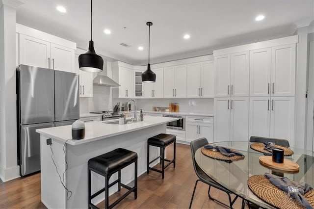 6890 Peachtree Dunwoody Rd Unit 303, Atlanta, GA 30328 - kitchen featuring appliances with stainless steel finishes, a sink, light countertops, dark wood-type flooring, and a kitchen bar