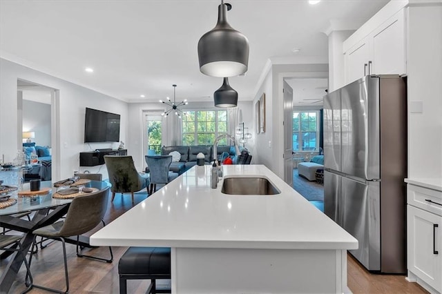 6890 Peachtree Dunwoody Rd Unit 303, Atlanta, GA 30328 - kitchen featuring freestanding refrigerator, a sink, open floor plan, healthy amount of natural light, and crown molding