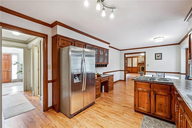 kitchen with stainless steel appliances, crown molding, and light hardwood / wood-style floors