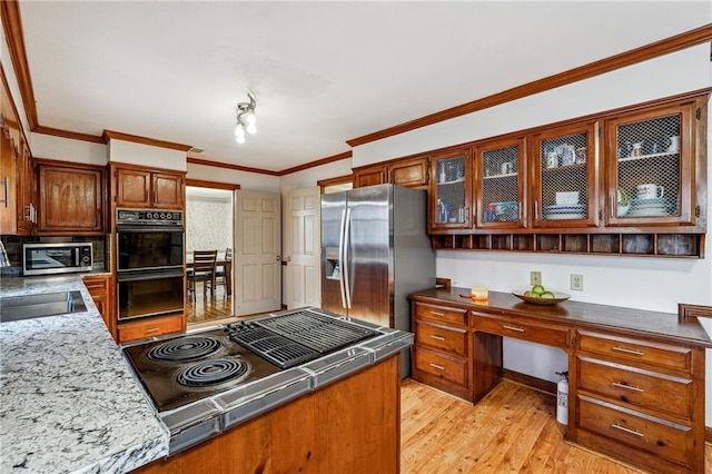 kitchen with stainless steel appliances, light hardwood / wood-style flooring, and ornamental molding