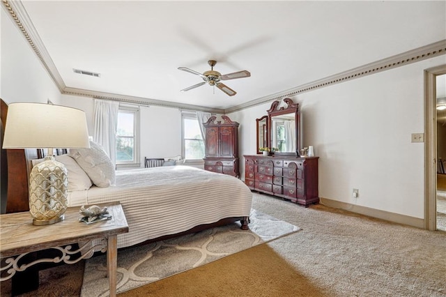 carpeted bedroom featuring ceiling fan and crown molding