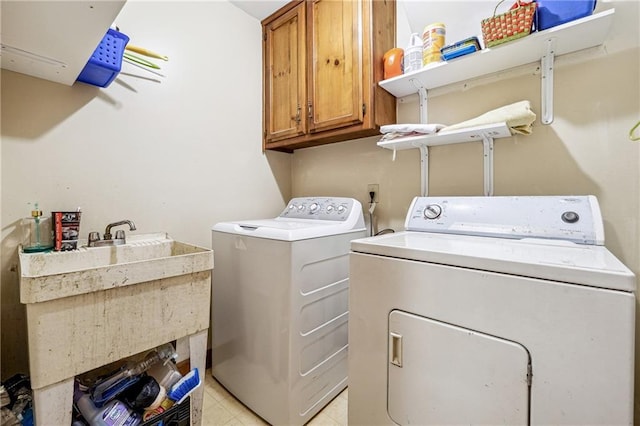 laundry room featuring cabinets, independent washer and dryer, and sink