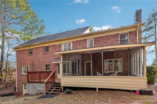 rear view of property featuring a wooden deck and a sunroom