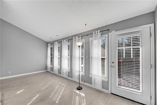 unfurnished room featuring lofted ceiling