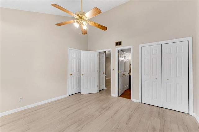 unfurnished bedroom featuring visible vents, light wood-style floors, a ceiling fan, high vaulted ceiling, and baseboards