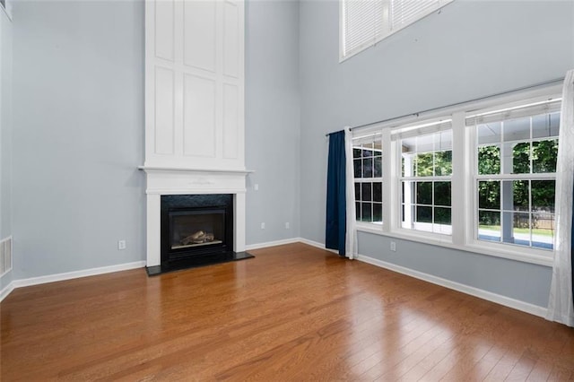 3362 Palm Cir NW, Kennesaw, GA 30144 - unfurnished living room with wood finished floors, a large fireplace, baseboards, and a high ceiling