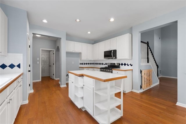 3362 Palm Cir NW, Kennesaw, GA 30144 - kitchen featuring stainless steel appliances, open shelves, white cabinets, backsplash, and arched walkways