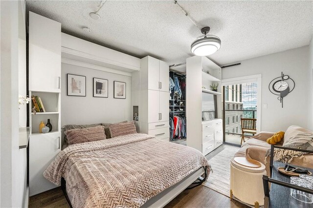 bedroom with a textured ceiling, hardwood / wood-style flooring, and a closet