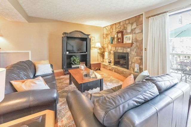 living room featuring a stone fireplace, a textured ceiling, and baseboards