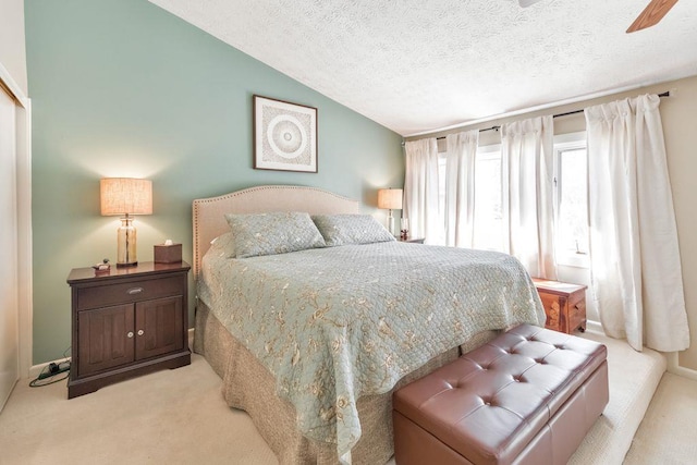 carpeted bedroom with ceiling fan, a textured ceiling, and lofted ceiling