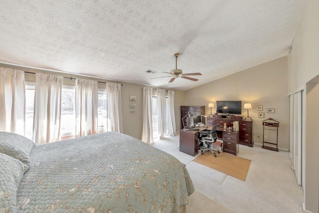 carpeted bedroom with a textured ceiling, vaulted ceiling, visible vents, and ceiling fan