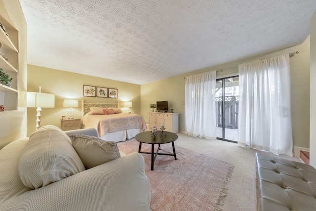 carpeted bedroom with access to exterior and a textured ceiling