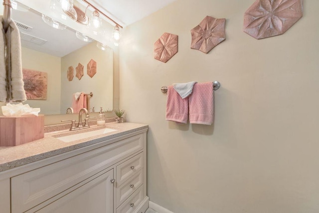 bathroom featuring vanity, baseboards, and visible vents