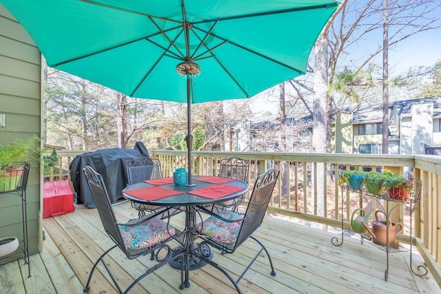 deck with a grill and outdoor dining area