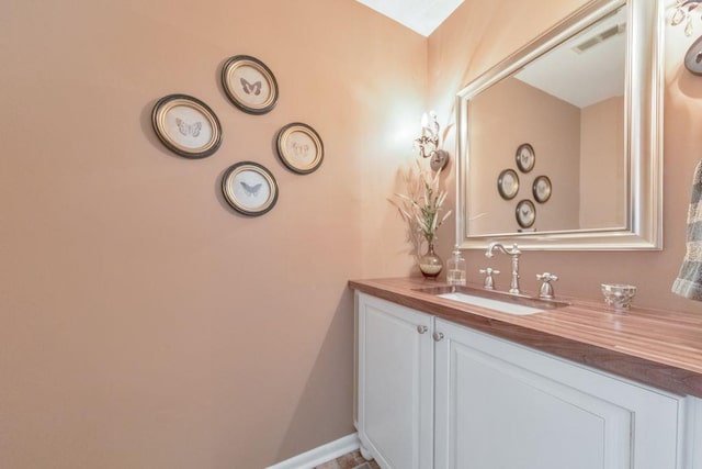 bathroom featuring visible vents, vanity, and baseboards