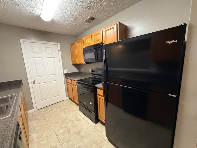 kitchen featuring black appliances, sink, and a textured ceiling