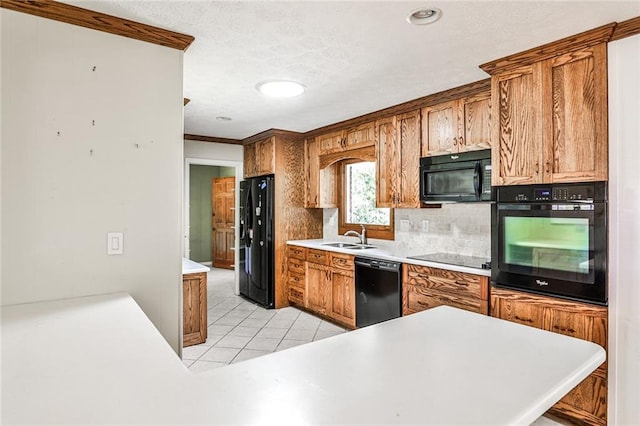 kitchen featuring light tile patterned flooring, a sink, light countertops, backsplash, and black appliances