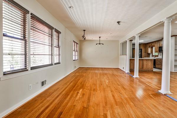 interior space with light wood-type flooring, decorative columns, visible vents, and baseboards