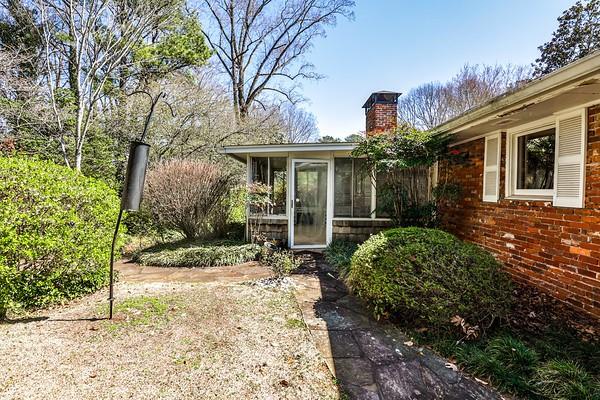 doorway to property featuring brick siding and a chimney