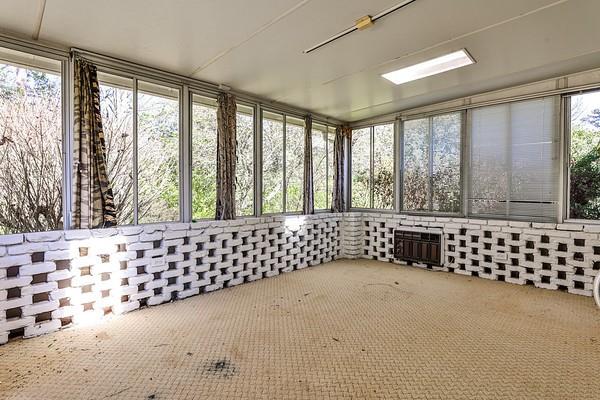 unfurnished sunroom featuring an AC wall unit