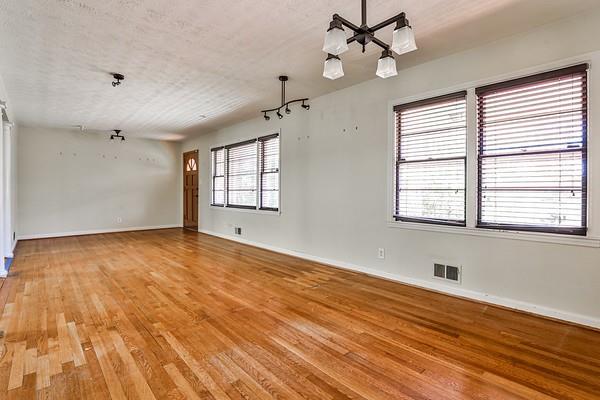 spare room featuring baseboards, a textured ceiling, visible vents, and light wood-style floors