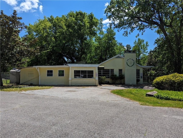 view of front of home with driveway and fence