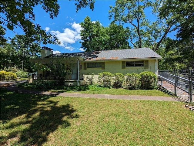 view of front facade with brick siding, fence, a chimney, and a front lawn