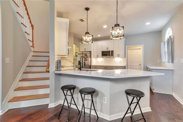 4360 Canterbury Walk Dr, Duluth, GA 30097 - kitchen featuring stainless steel appliances, a chandelier, a sink, a peninsula, and a kitchen bar