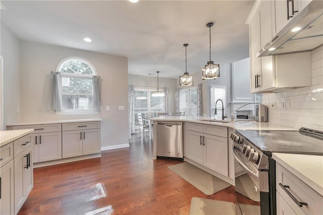 4360 Canterbury Walk Dr, Duluth, GA 30097 - kitchen featuring appliances with stainless steel finishes, a sink, under cabinet range hood, dark wood-type flooring, and recessed lighting