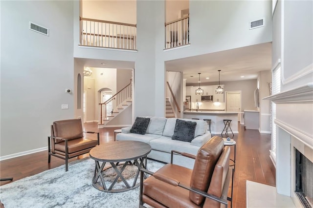 4360 Canterbury Walk Dr, Duluth, GA 30097 - living area with a high ceiling, dark wood-style floors, stairway, baseboards, and arched walkways