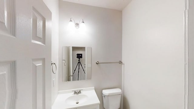 half bath featuring toilet and vanity