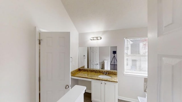 bathroom featuring vanity, a healthy amount of sunlight, baseboards, and a textured ceiling