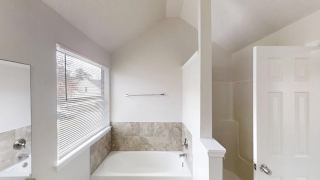 full bathroom with vaulted ceiling and a bath