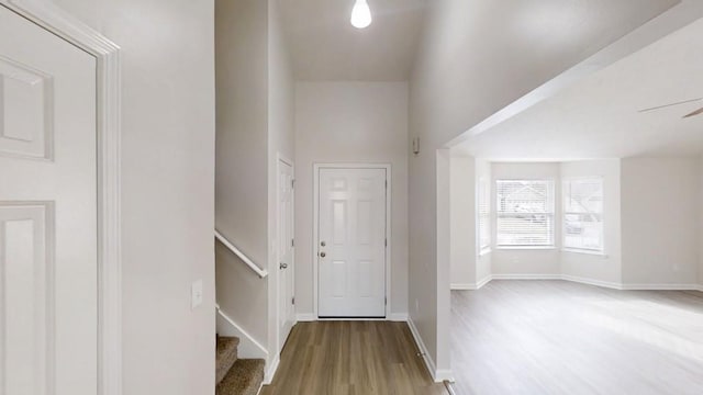 foyer featuring stairs, baseboards, and wood finished floors