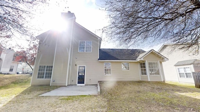 back of property with a lawn and a patio area